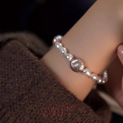 Natural color lavender baroque pearl bracelet on wrist close-up highlighting smooth freshwater pearls and statement center pearl