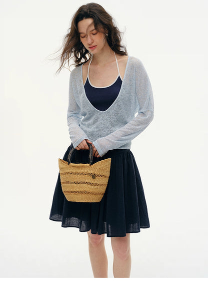 Sky Ice Blue layered V-neck knit styled with navy skirt and straw summer bag