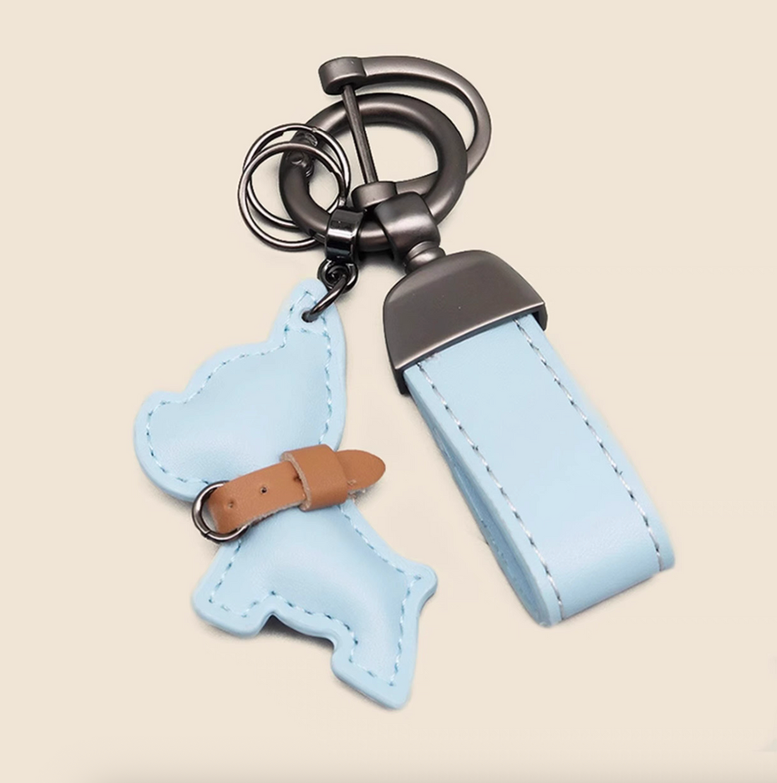 Light blue PU leather puppy keychain with wrist strap and dog silhouette charm.