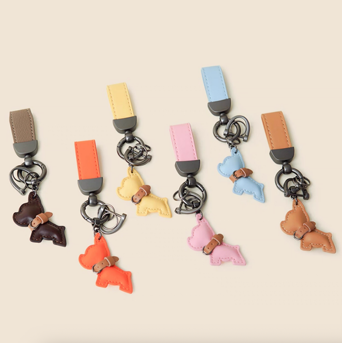 Set of six PU leather puppy keychains in brown, orange, yellow, pink, blue, and tan.