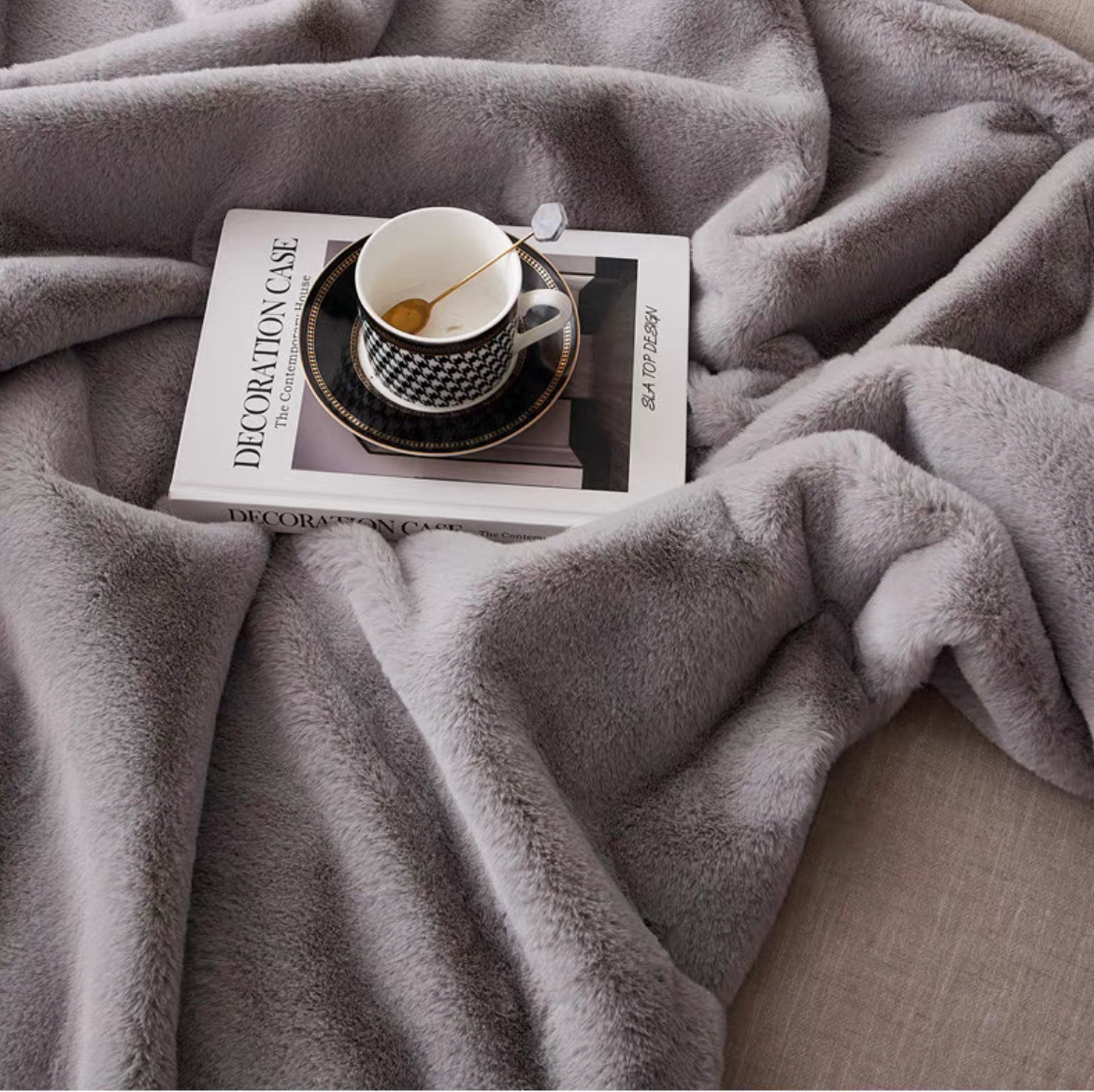 Close-up of light gray faux fur throw blanket highlighting plush texture and softness
