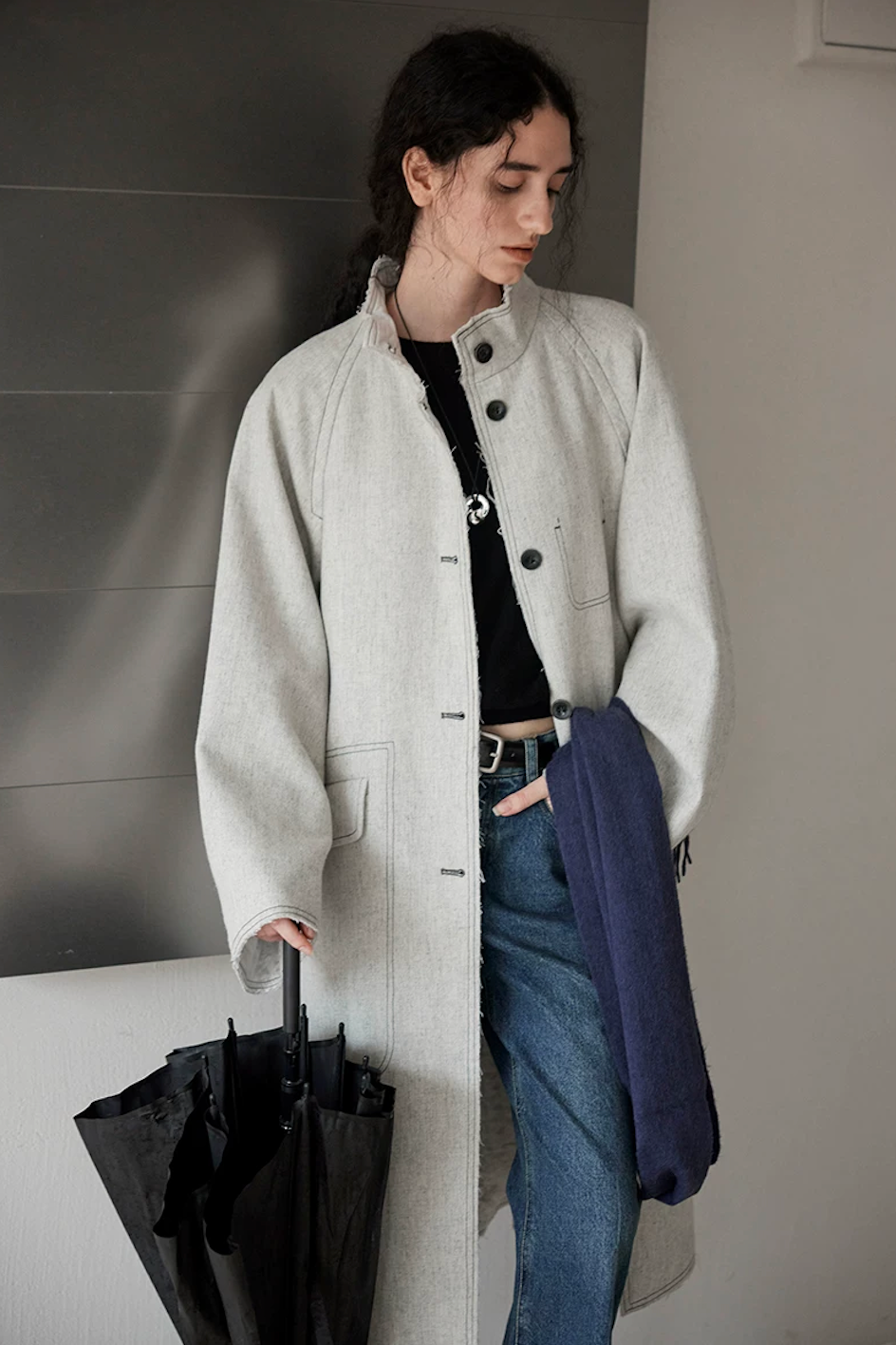 Light gray raw-edge padded coat worn open with stand collar and flap pocket, front view