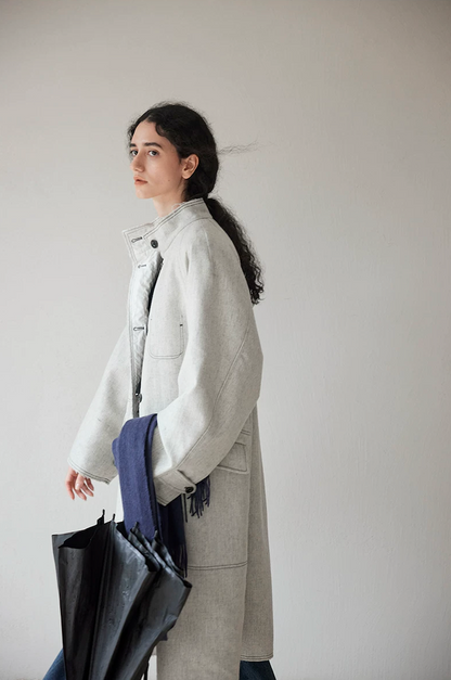 Side view of a light gray stand-collar wool-blend coat with raglan sleeves