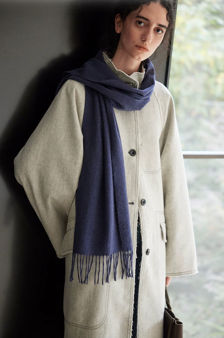 Light gray wool-blend coat showing the side flap pocket and raw-edge placket