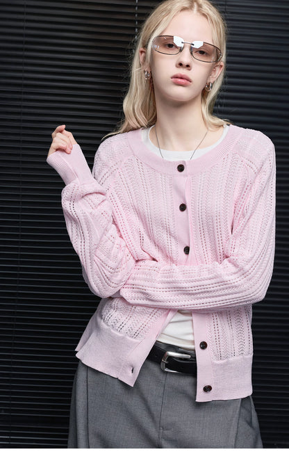 Close-up of Light Pink cardigan showing openwork knit sleeves, crew neckline and dark round buttons