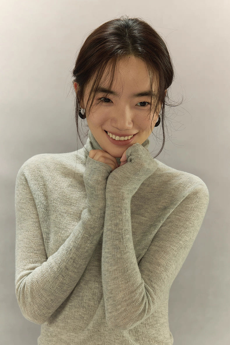 Light Gray turtleneck soft expression portrait, showing sleeve length.