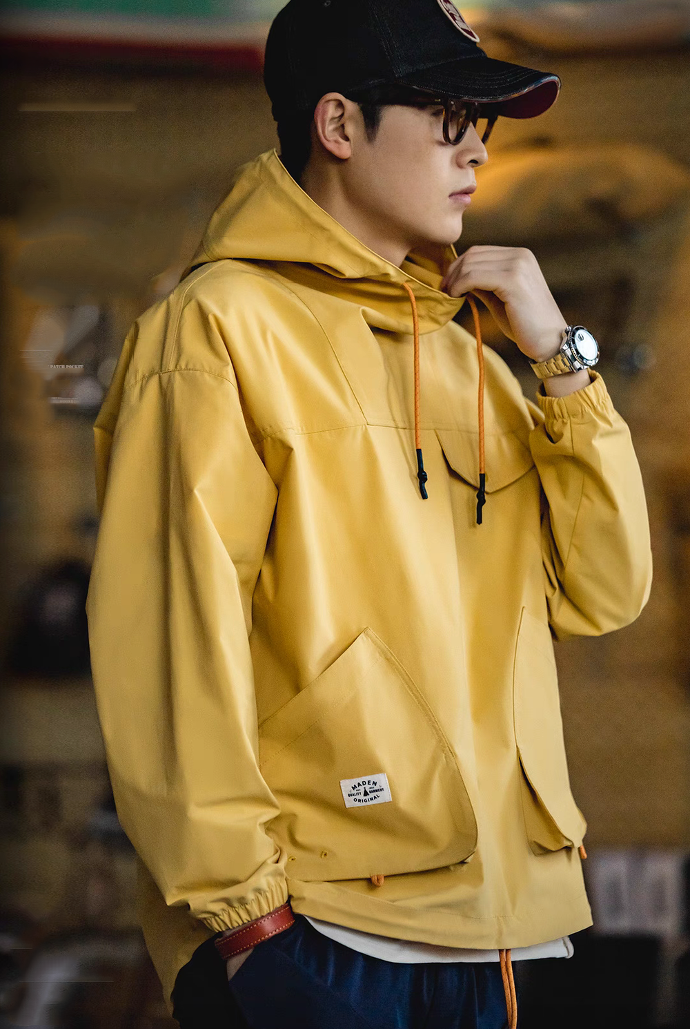 Side view of Ginger Yellow Lightweight Hooded Anorak Jacket worn by model showing sleeve shape, hood and relaxed silhouette