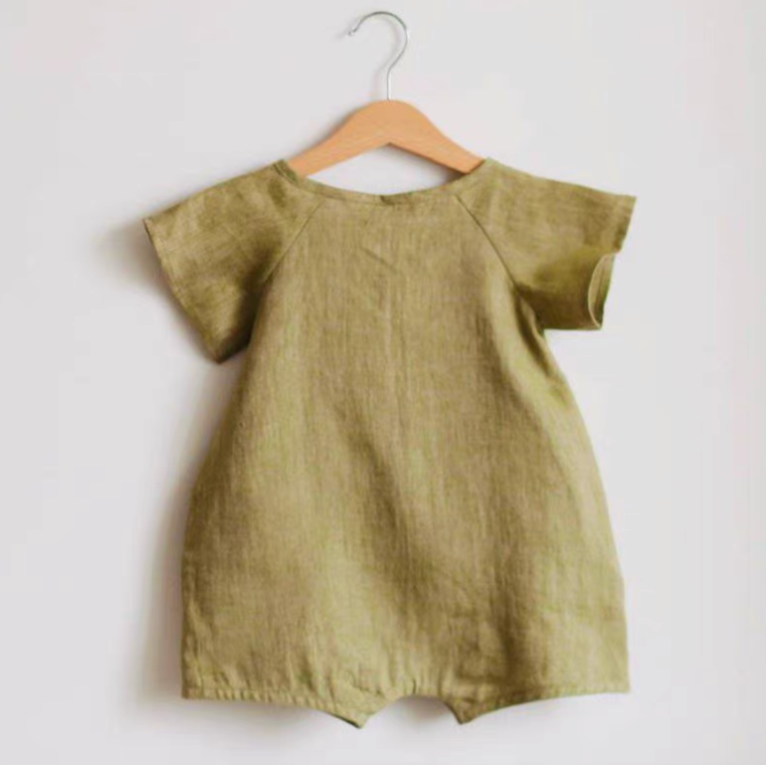 Back view of green lightweight cotton muslin baby romper hanging on hanger