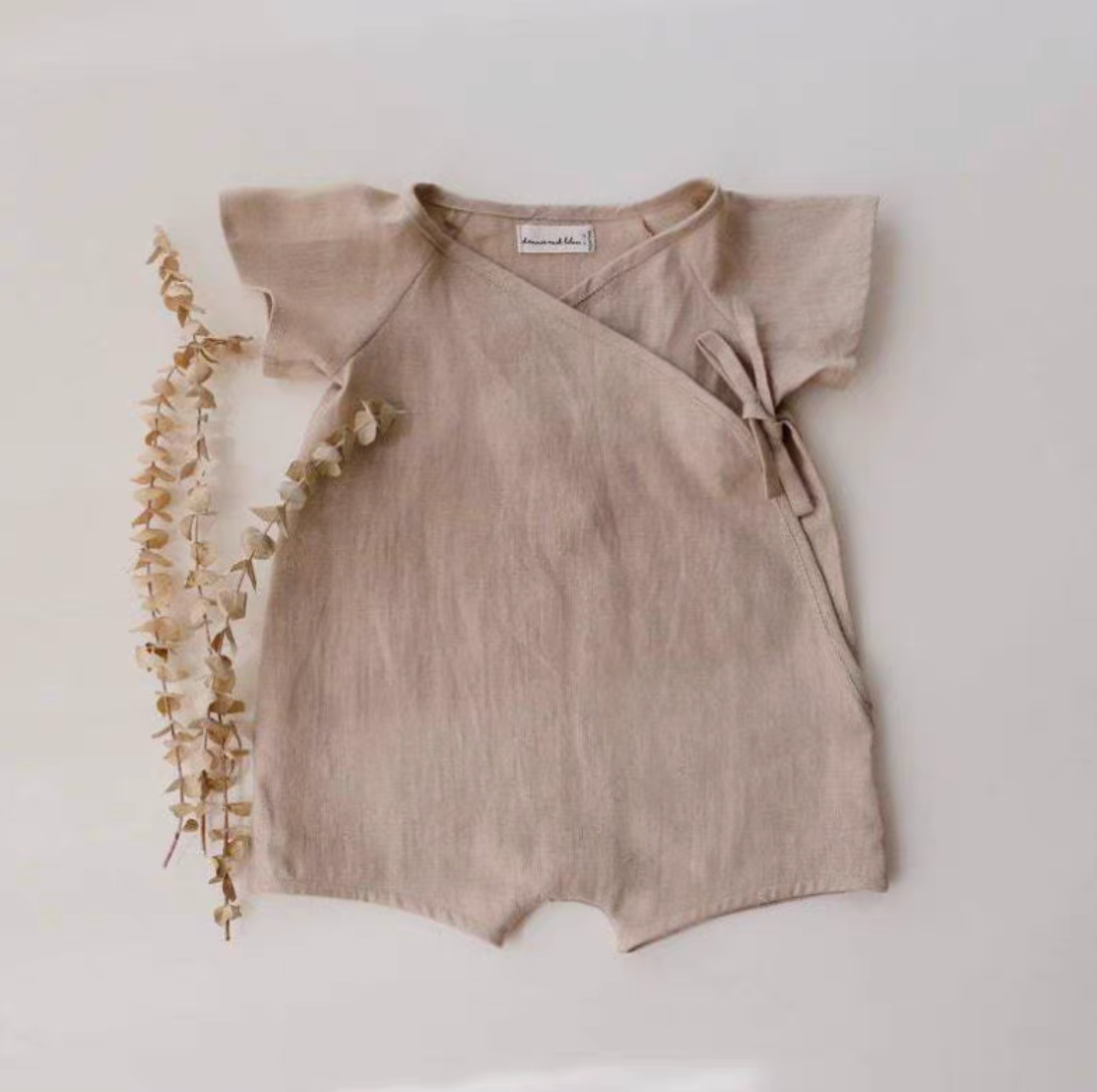 Oatmeal cotton muslin baby romper with wrap tie closure front view