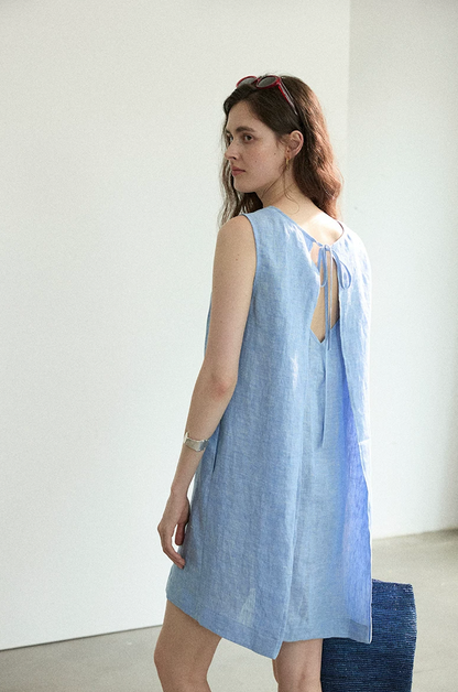 Close-up of chambray blue linen dress pleated tie-back detail