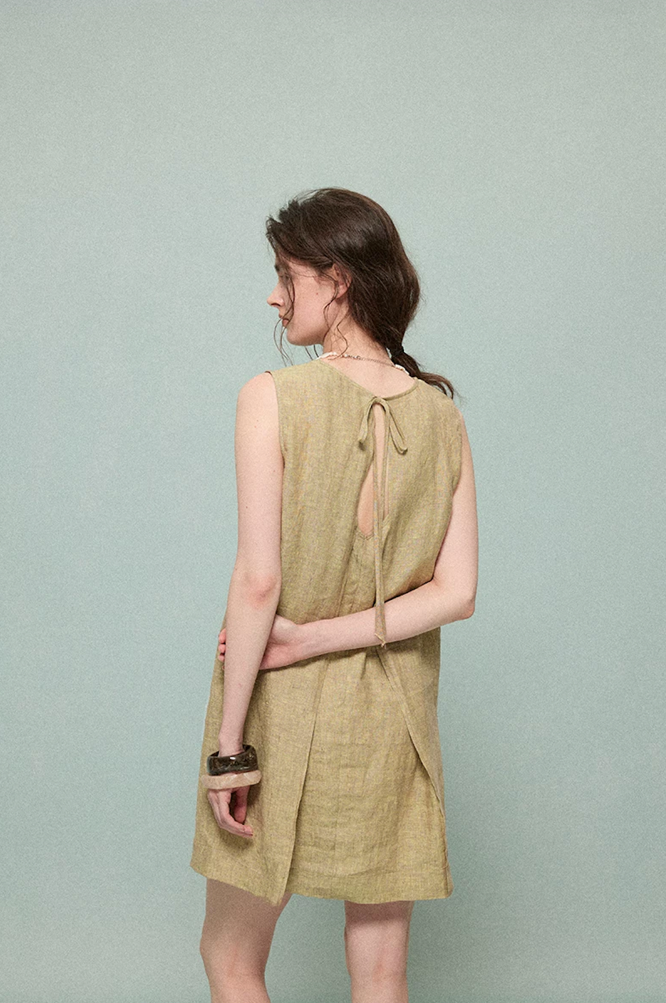 Close-up of olive linen dress pleated tie-back detail