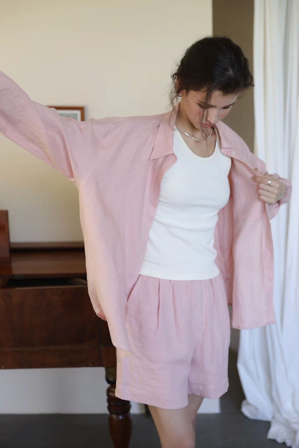Pink linen collared shirt worn open with white tank top front detail showing lightweight fabric