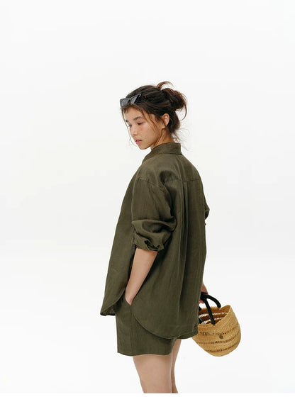 Woman wearing olive green embroidered linen shirt, side back view