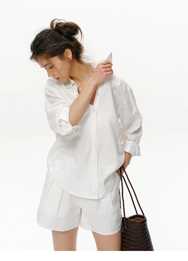 Close-up of white linen shirt collar and embroidered logo detail