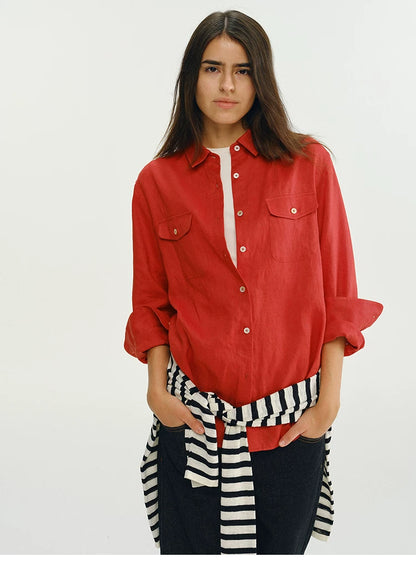 Woman wearing red linen utility shirt with striped tie belt, front view