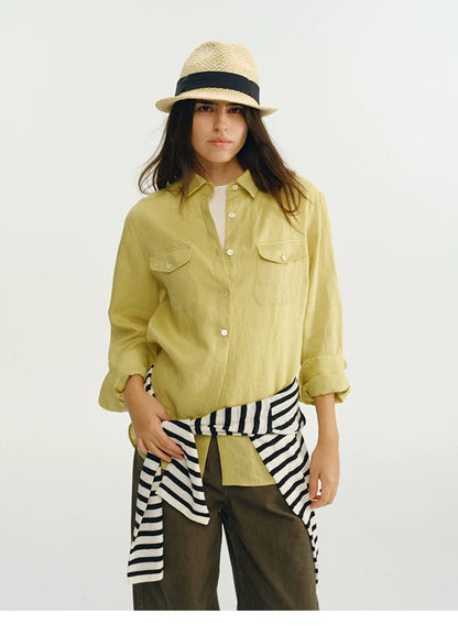 Woman wearing yellow linen utility shirt with straw hat, front view