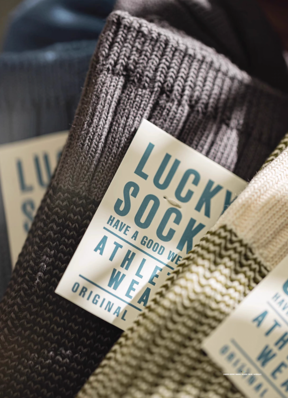 Close-up of Lucky Chunky Knit Socks in black showing thick ribbed knit texture and Lucky Socks label packaging detail