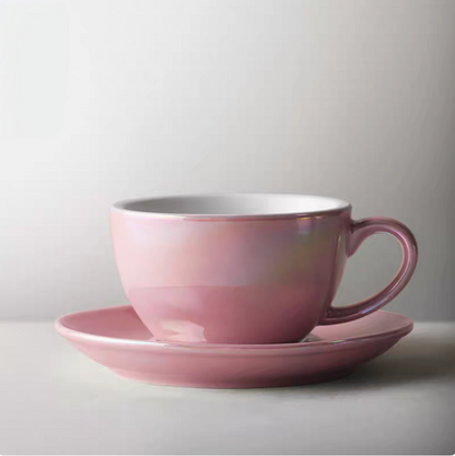 Luminous iridescent pink ceramic coffee cup and saucer set in front view with glossy pearl finish and smooth rounded shape