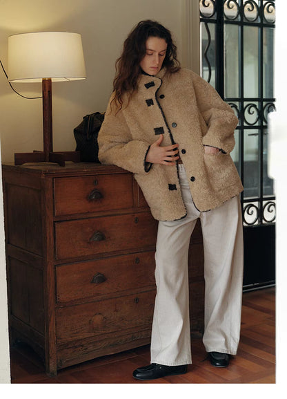 Model styling Luxe Contrast Shearling Coat in Apricot Beige short style with relaxed fit, front pockets, and casual indoor outfit