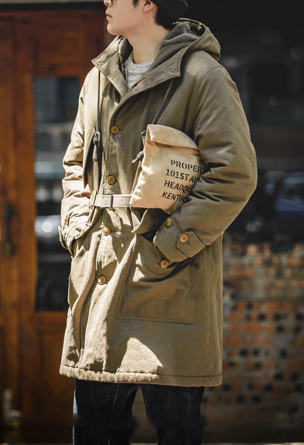 M47 Heritage Explorer Parka Coat in military green side view worn by model highlighting relaxed fit, hood, and utility pocket styling