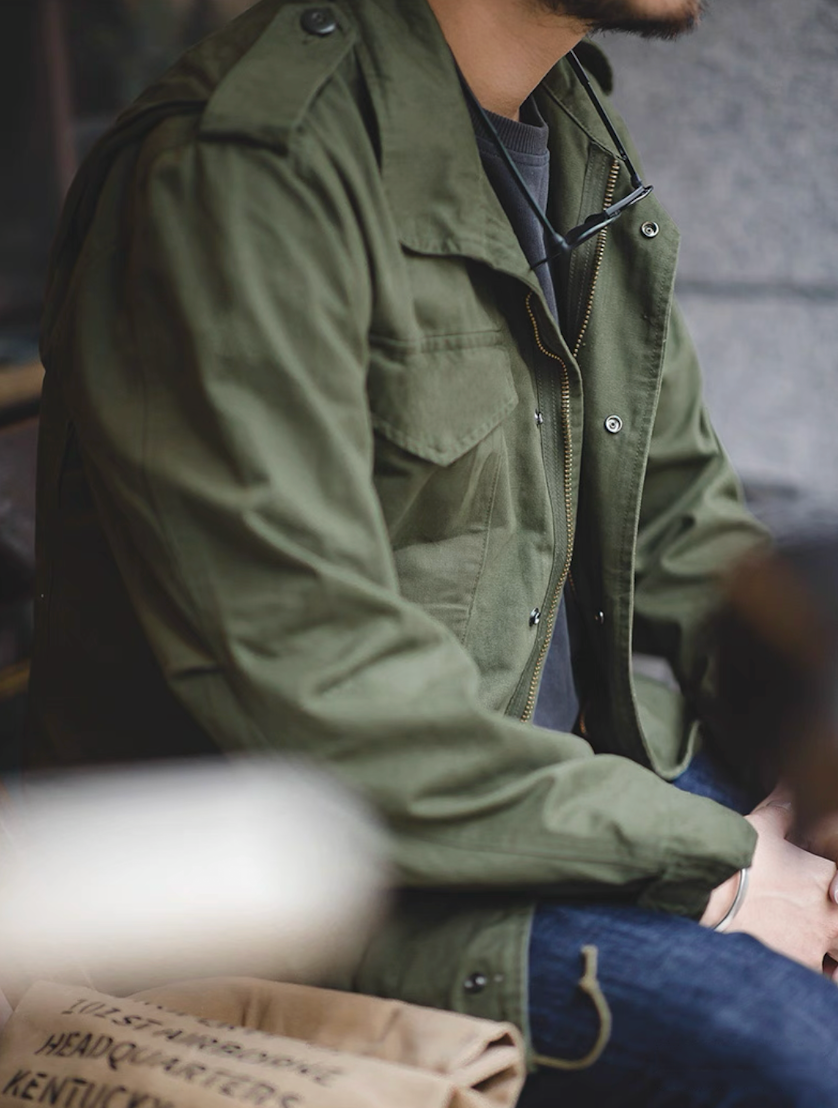 Side Profile of M65 Field Jacket in Casual Seated Look with Olive Green Jacket