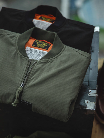 Folded MA-1 bomber jackets in green and black with lining