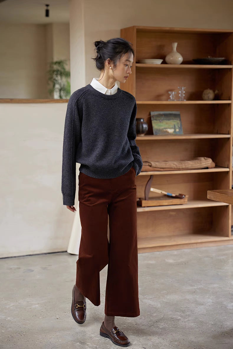 Shale gray merino wool sweater worn walking in minimalist interior paired with tailored pants for effortless style