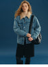 Front view of a Medium Blue padded denim trucker jacket with silver-tone buttons and boxy fit
