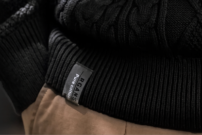 Ribbed hem with label, men’s cable knit black sweater.
