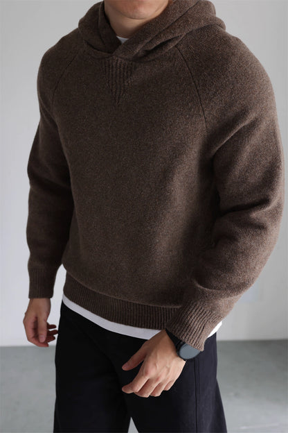 Side angle of coffee brown knit hoodie, showing clean no-drawstring hood and ribbed cuffs