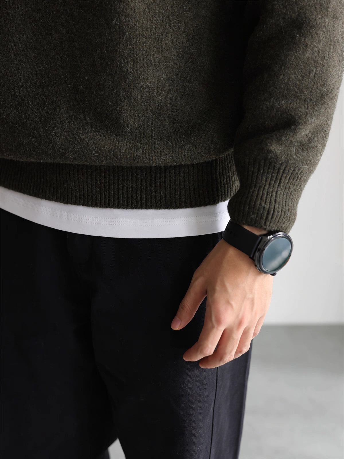 Close-up of ribbed hem and cuff on olive knit hoodie sweater
