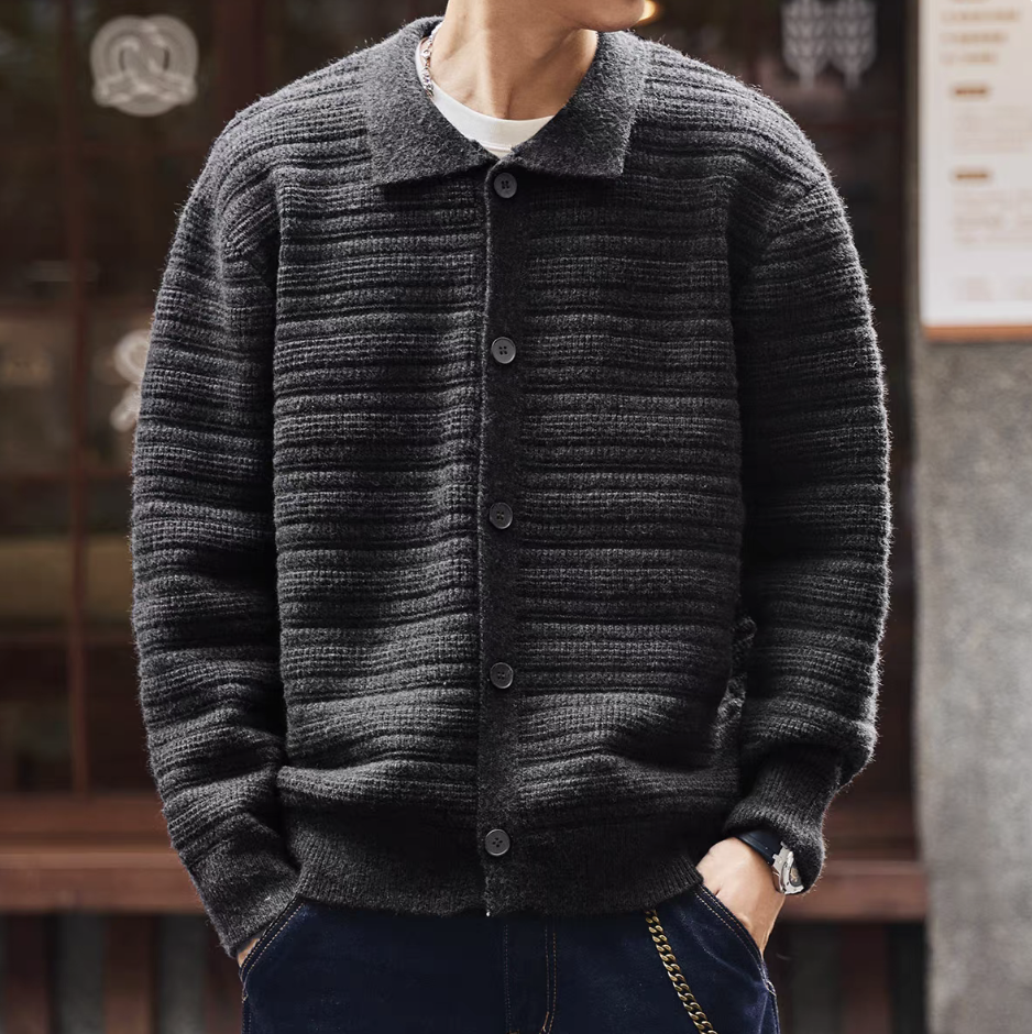 Man wearing dark grey ripple-textured knit cardigan with shirt collar and button front, styled casually with jeans.