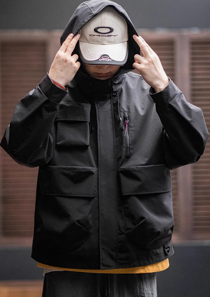 Man wearing Black Metro Flex Waterproof Jacket adjusting the hood, showing high collar, front zip closure and multi-pocket design