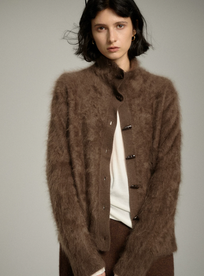 Mocha fuzzy cashmere cardigan worn partly unbuttoned over a white top, showing the ribbed placket