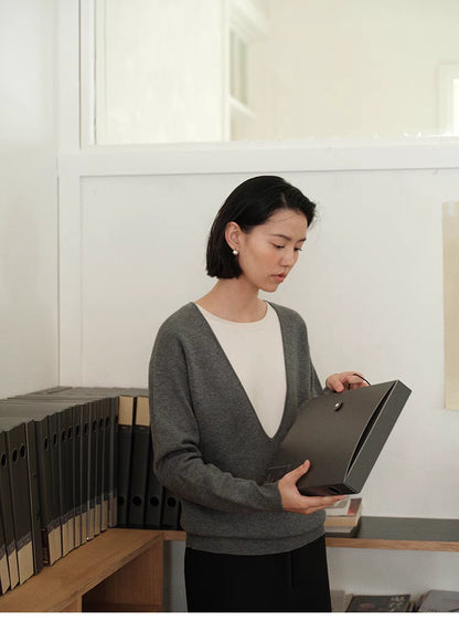 Front view of Dark Gray Modern V-Neck Relaxed Sweater with model holding box showing minimalist design and layering style