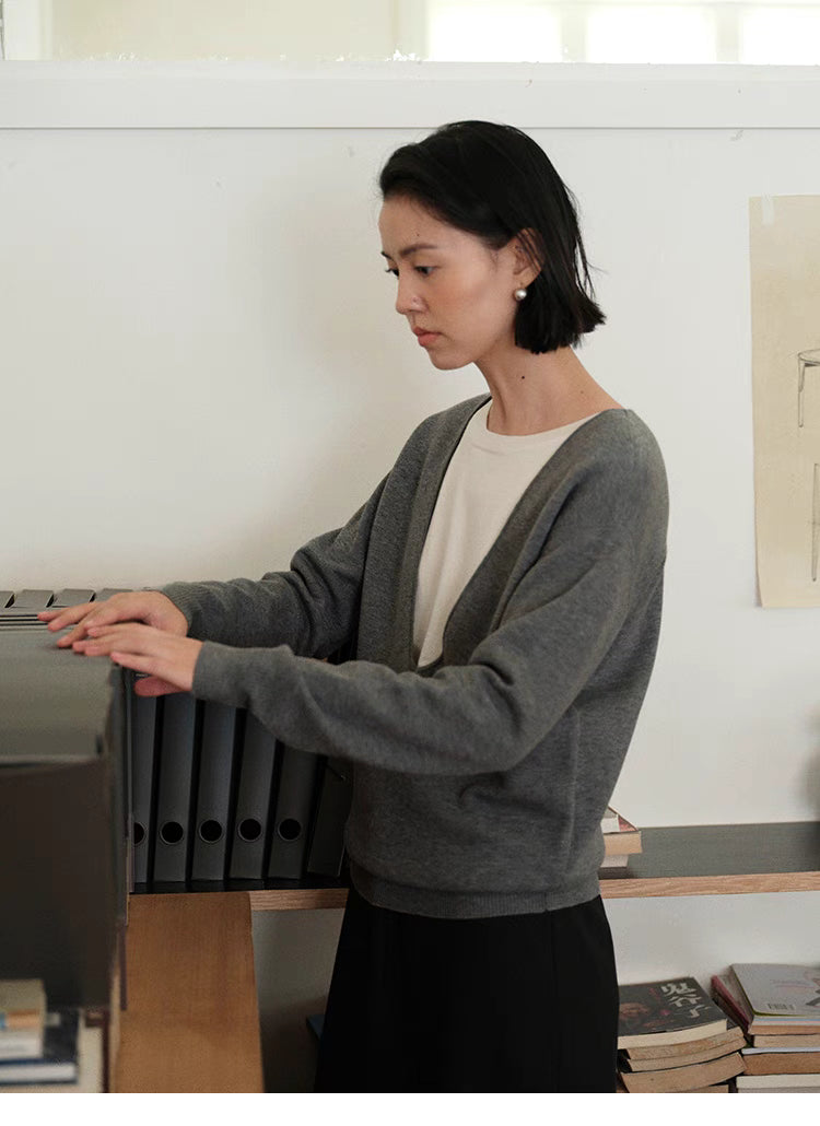 Side view of Dark Gray Modern V-Neck Relaxed Sweater organizing files showing relaxed silhouette and everyday office styling