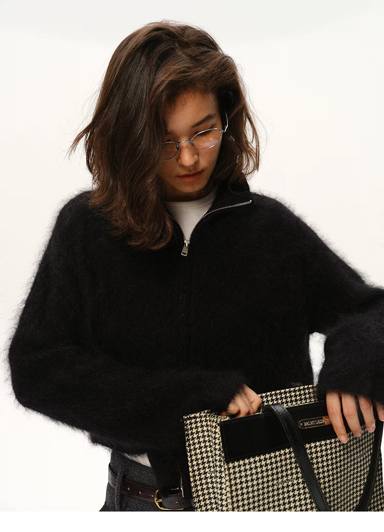 Close-up of black mohair zip cardigan paired with houndstooth bag