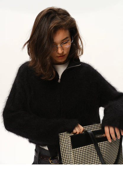 Close-up of black mohair zip cardigan paired with houndstooth bag
