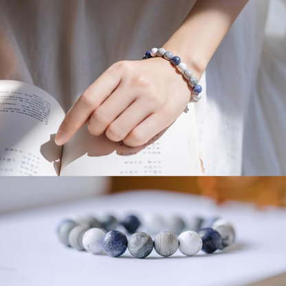 Minimalist gradient blue bracelet worn on wrist showing white howlite, gray vein, and blue stone beads in natural light