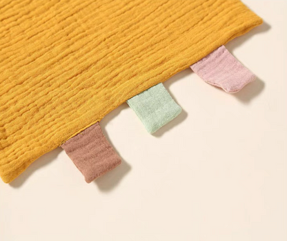 Yellow baby comfort cloth toy colorful tag detail close-up
