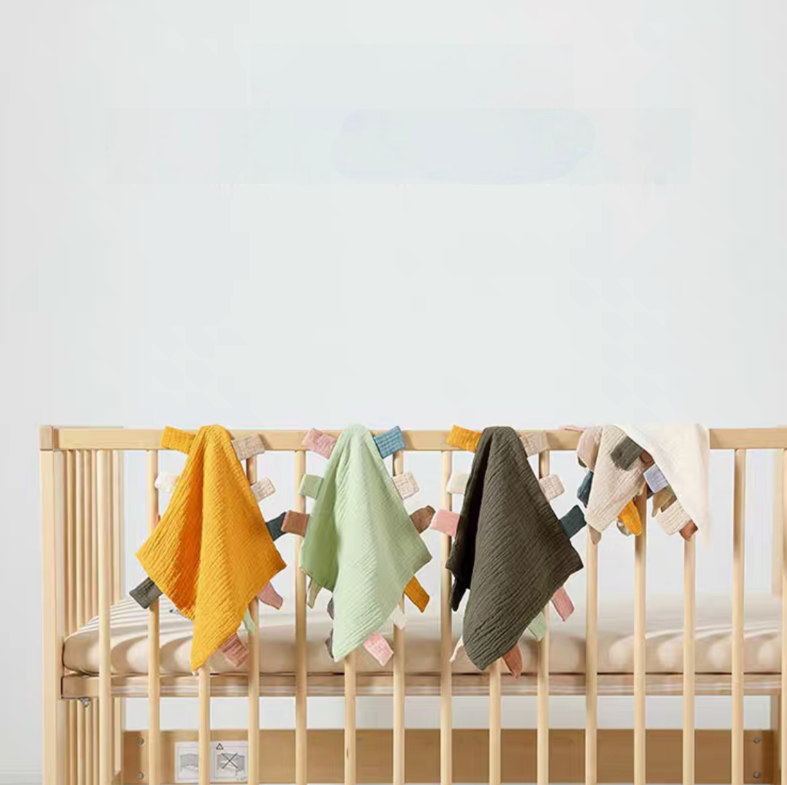 Multicolor sensory baby comfort teething cloth toys hanging on crib rail in nursery setting