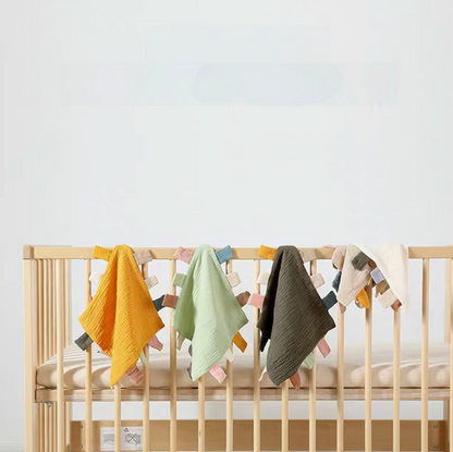 Multicolor sensory baby comfort teething cloth toys hanging on crib rail in nursery setting