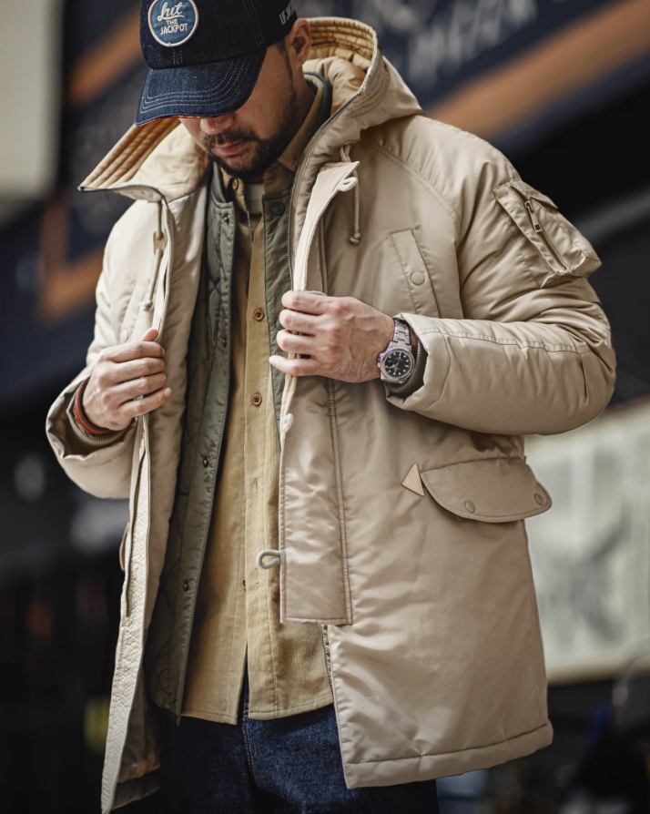 Model wearing khaki N-3B parka layered over green shirt, front view.