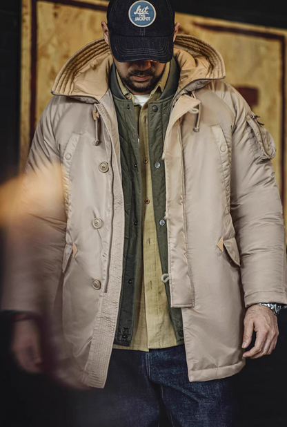 Model outdoors wearing khaki N-3B parka with quilted lining visible.