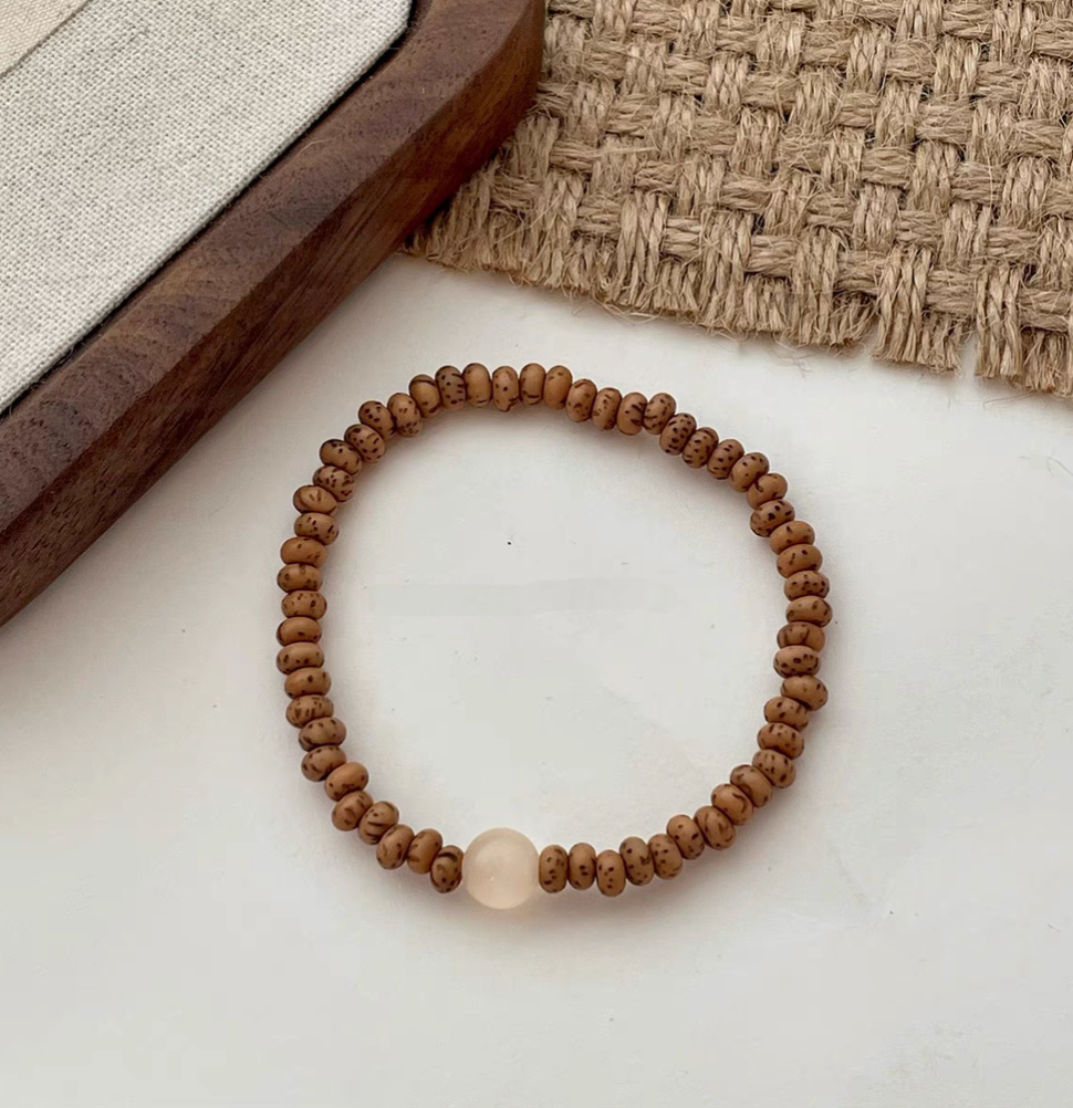close-up flat lay of bodhi seed bracelet with cat&