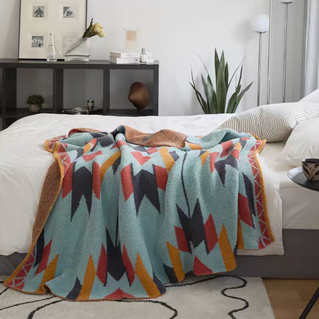 Ashia chenille throw blanket with colorful zigzag geometric pattern spread across bed