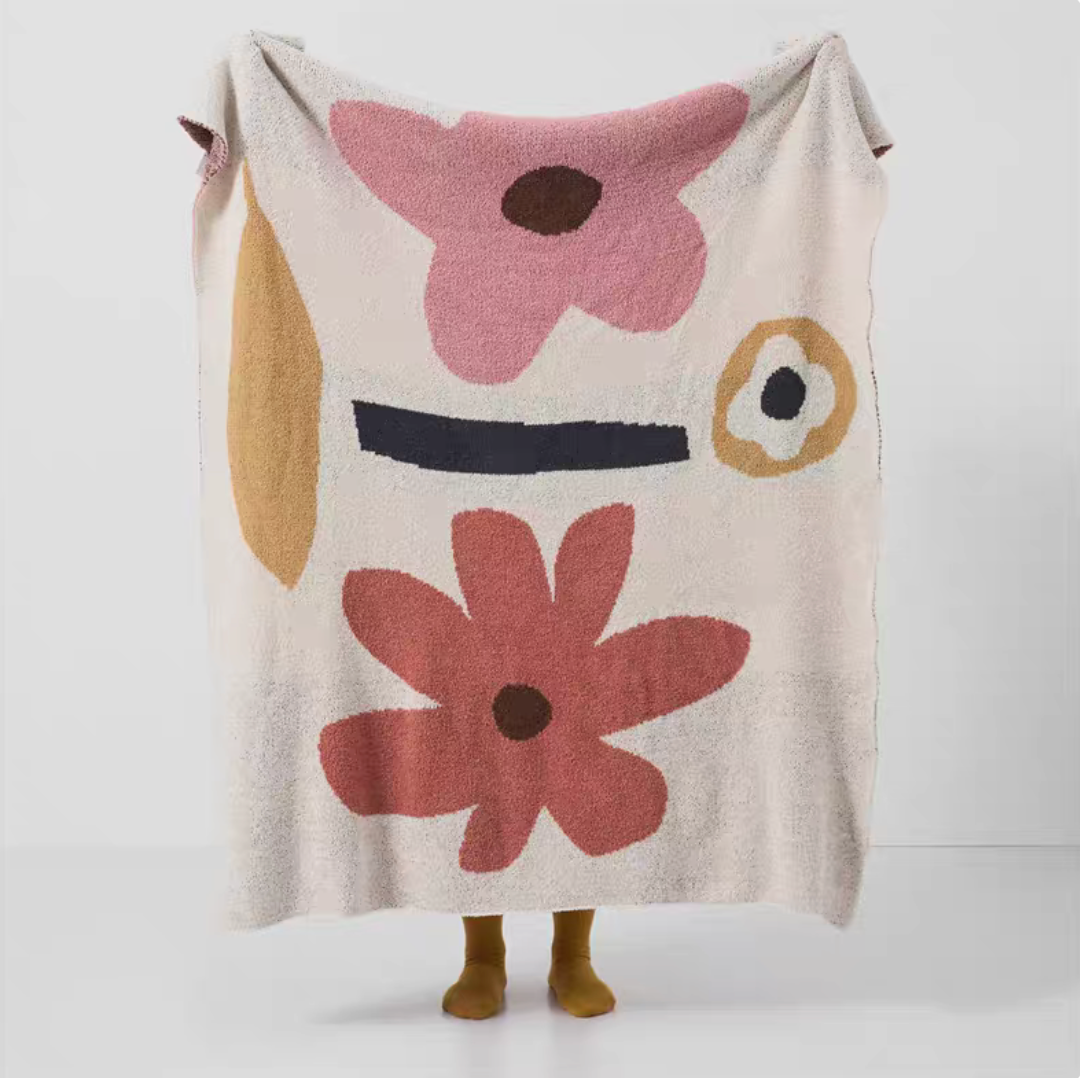 Floral letter chenille throw blanket with abstract flower shapes held up showing full pattern design