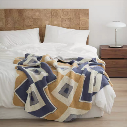 Layge chenille throw blanket with navy blue and beige geometric square pattern spread on bed