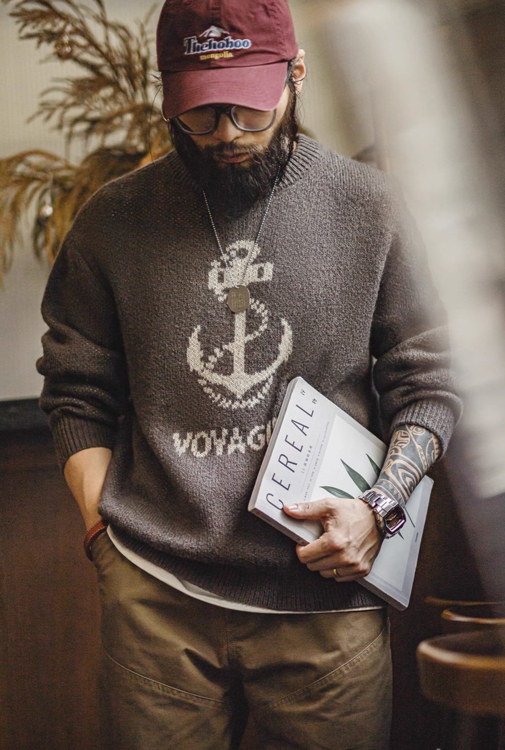 Man wearing Nautical Anchor Knit Sweater Gray Brown holding book showing relaxed silhouette and anchor knit design