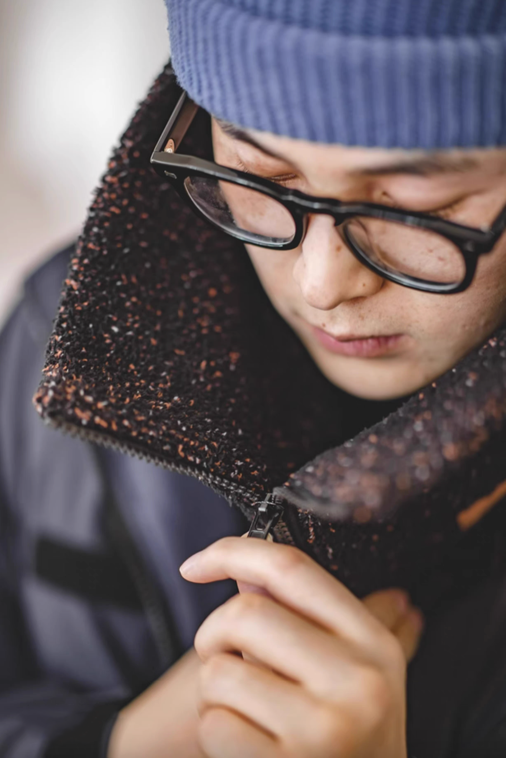 Model wearing Starry Black Navajo-Inspired Half-Sherpa Neck Warmer zipped up for warmth and wind protection
